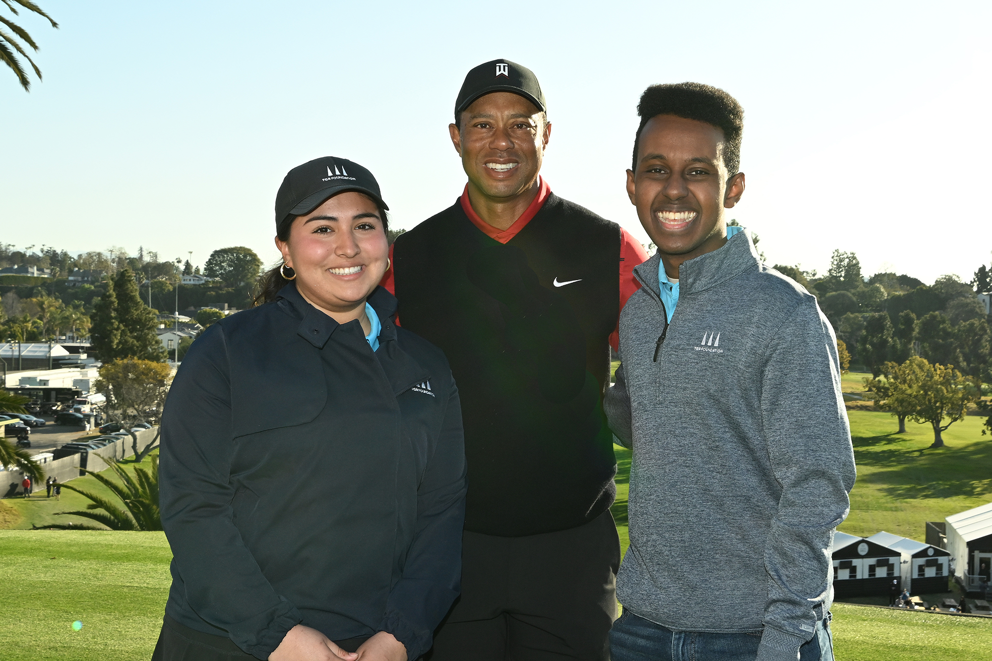 Tiger Woods with TGR Learning Lab students Ariana Perez (left) and Sammy Mohammed (right)